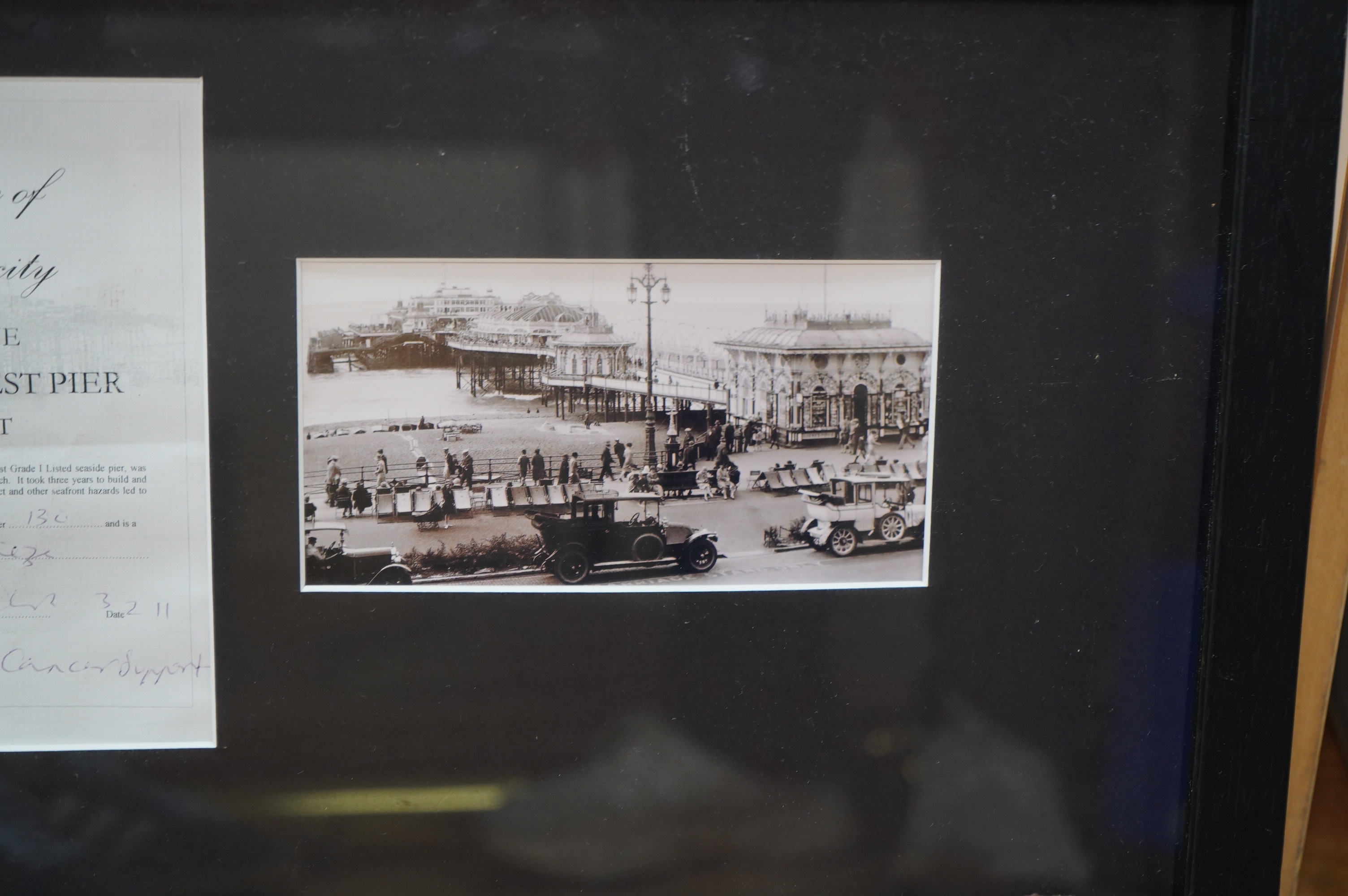 A framed part of the original frieze from the West Pier in Brighton, a photo and certificate, plus a book about the West Pier, 50cm wide, 40cm high. Condition - good